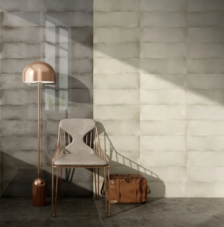 Sedia, lampada da terra e borsa davanti a una parete in piastrelle beige e grigie